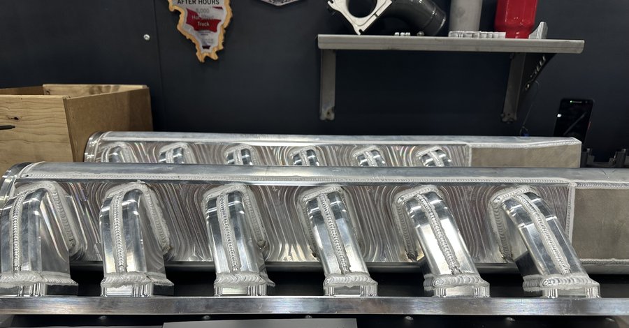 Detailed view of welded CNC intake runners with precision port alignment
